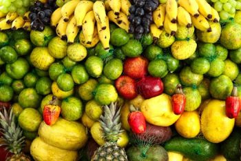 A colorful arrangement of assorted tropical fruits including bananas, apples, pineapples, and citrus.