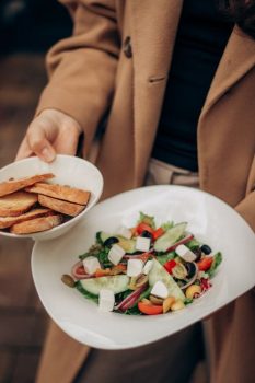 Close-up of a colorful Mediterranean salad with fresh vegetables and bread slices.