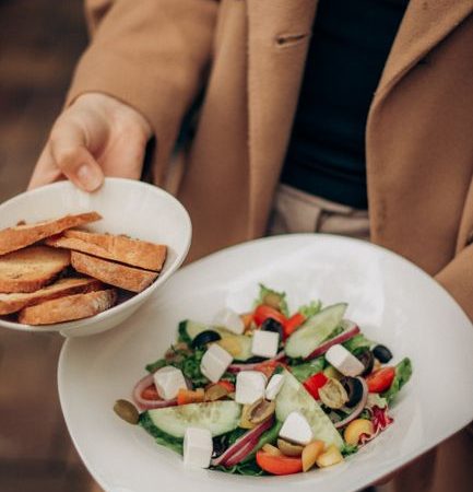 Close-up of a colorful Mediterranean salad with fresh vegetables and bread slices.